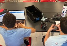 Two middle school students coding and building a car