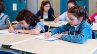 Elementary students writing in notebooks