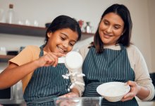Mother and daughter measuring flour for baking