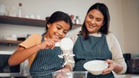 Mother and daughter measuring flour for baking