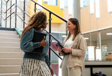 Two teachers talking on a school staircase