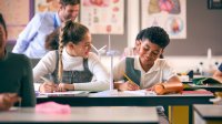 A photo of two middle school students discussing the function of windmill model