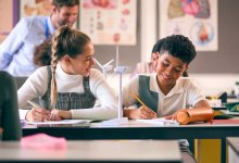A photo of two middle school students discussing the function of windmill model