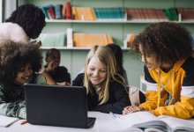 Small group of elementary students working together using a laptop