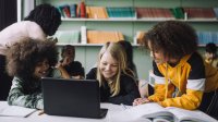 Small group of elementary students working together using a laptop
