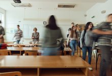 High school teacher watching as students arrive in class