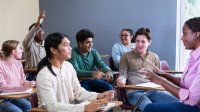 A student raising their hand to participate in a class discussion