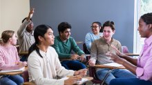 A student raising their hand to participate in a class discussion