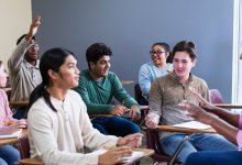A student raising their hand to participate in a class discussion