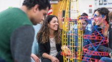 Physics teacher working with students on a project