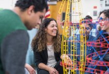 Physics teacher working with students on a project