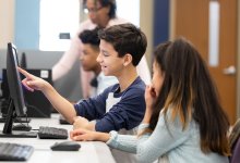 A photo of a pair of middle school students working on a coding assignment together