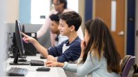 A photo of a pair of middle school students working on a coding assignment together